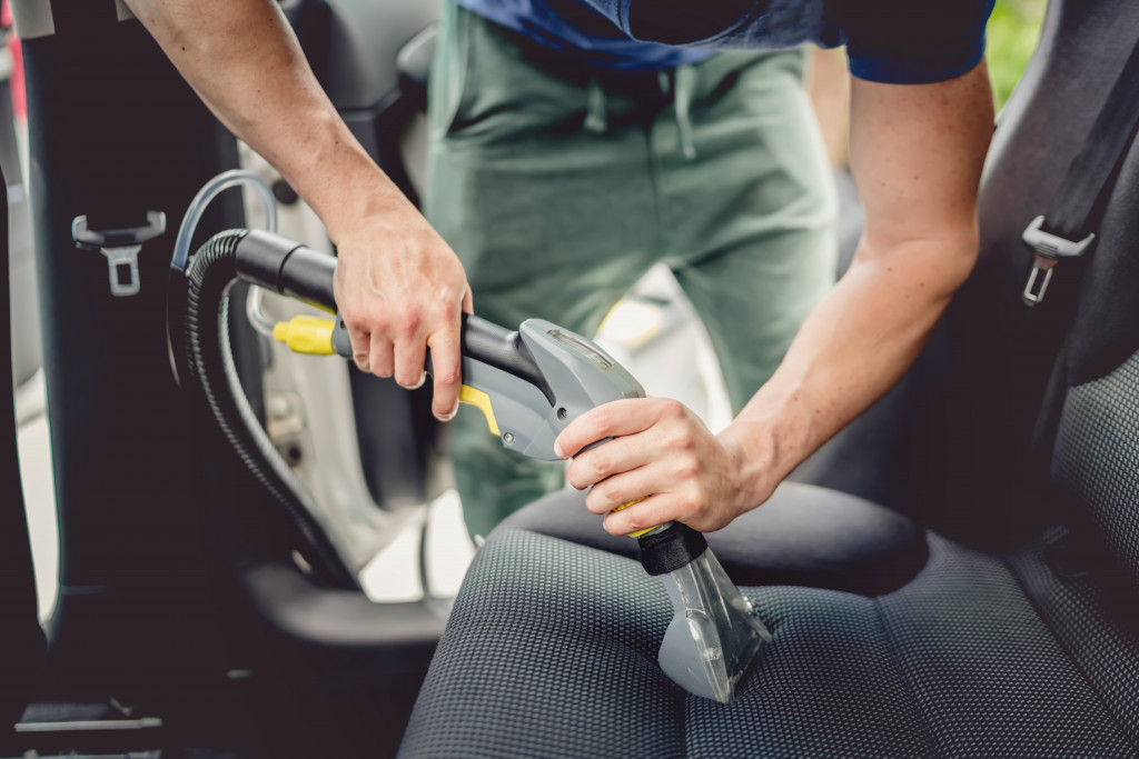 man deep cleaning car seat