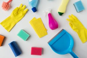 scattered cleaning materials and products in a white background